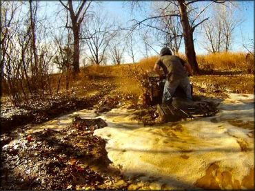 ATV going through a deep mud puddle.