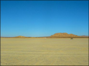 View of flat lakebed with two dirt bikes.