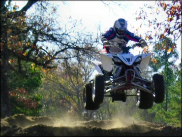 Yamaha Raptor ATV catching some air on the motocross track.