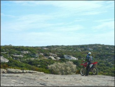 A rider sitting on Honda CRF150F dirt bike taking in the view.