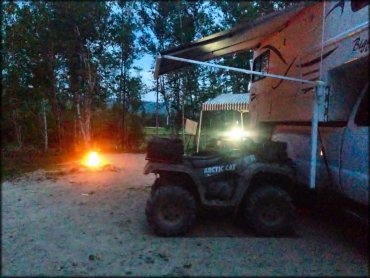 Arctic Cat ATV parked next to Bigfoot Camper and pop up tent.