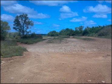 View of play area with small jumps, hard pack and loose chunk rock.