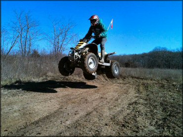 Yamaha Banshee ATV with orange whip flag catching some air.