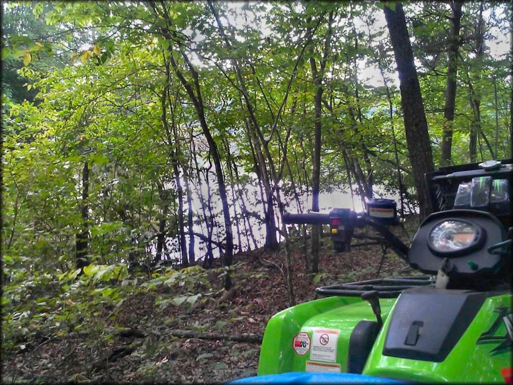 Arctic Cat ATV parked off the trail overlooking lake.