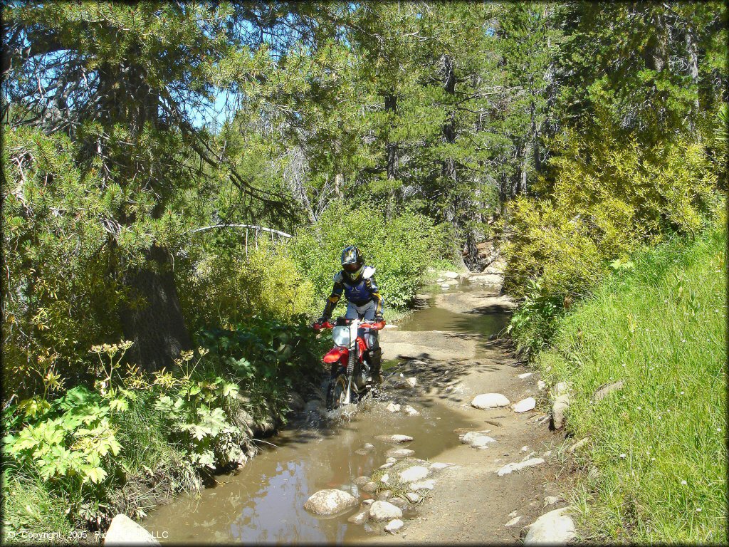 Honda CRF Motorcycle crossing the water at Lower Blue Lake Trail