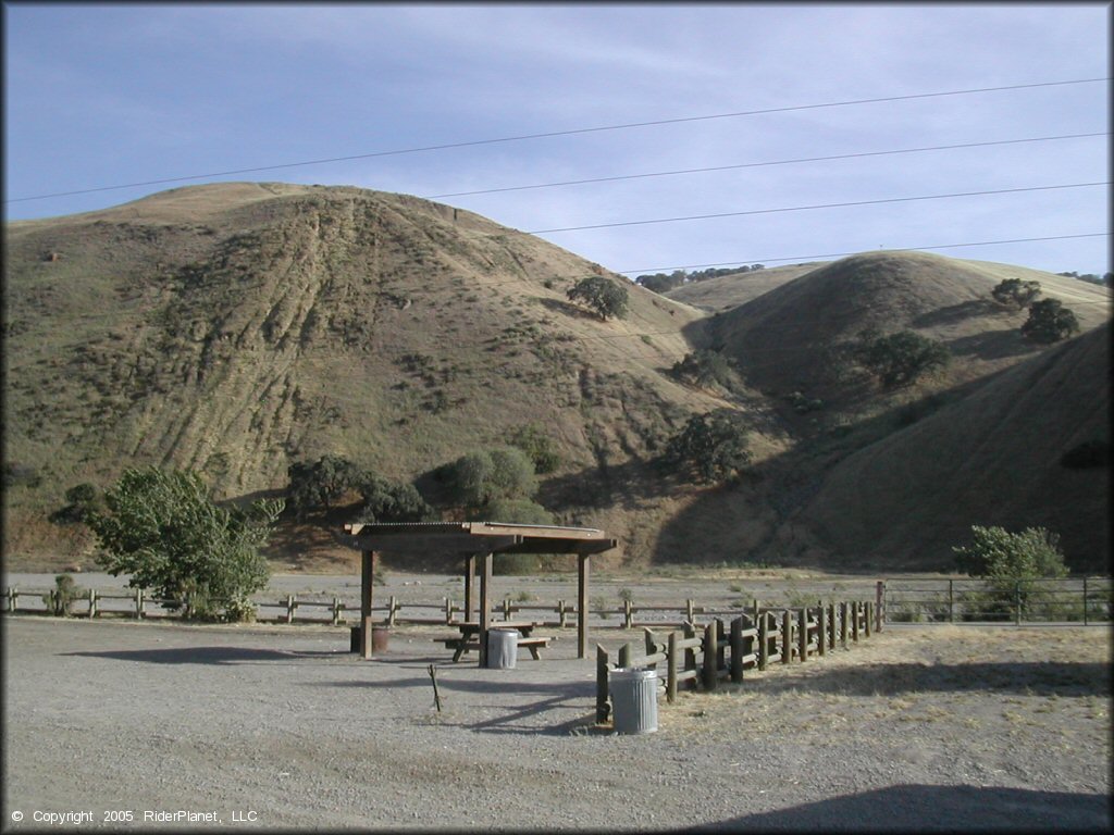 Campsite at Carnegie SVRA with shade gazebo, picnic table, fire ring and trash cans.