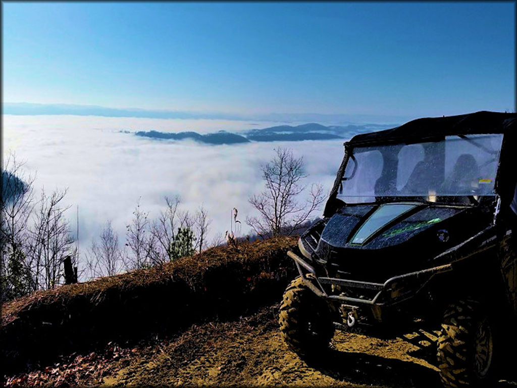 Blue UTV with tow winch overlooking scenic view of Appalachian Mountains with clouds in the valley.