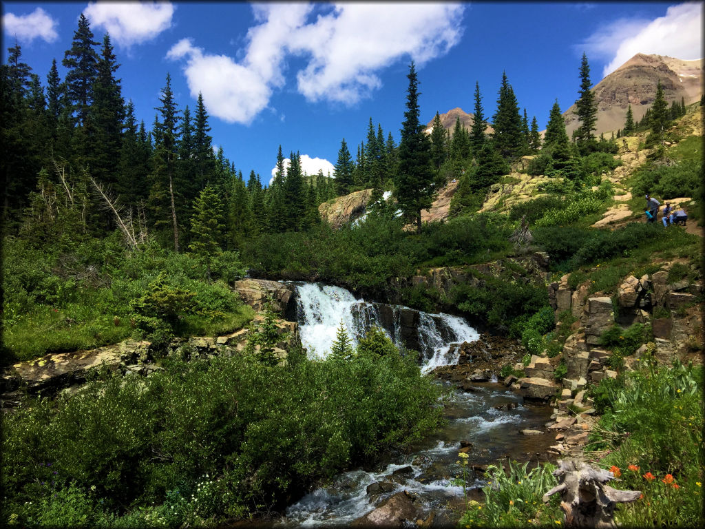 Scenic photo of creek surrounded by woods and mountain alongside the Alpine Loop.