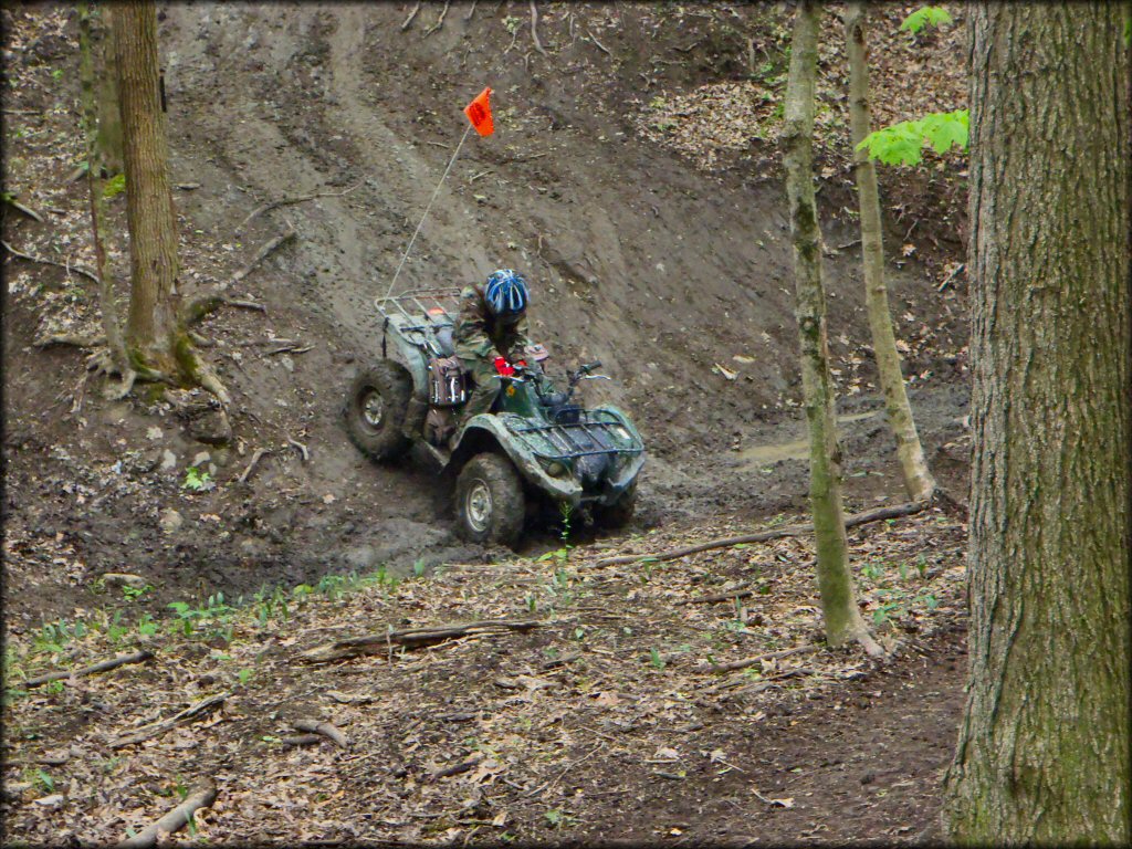 ATV rider going down a muddy hill at The Cliffs Offroad Park.