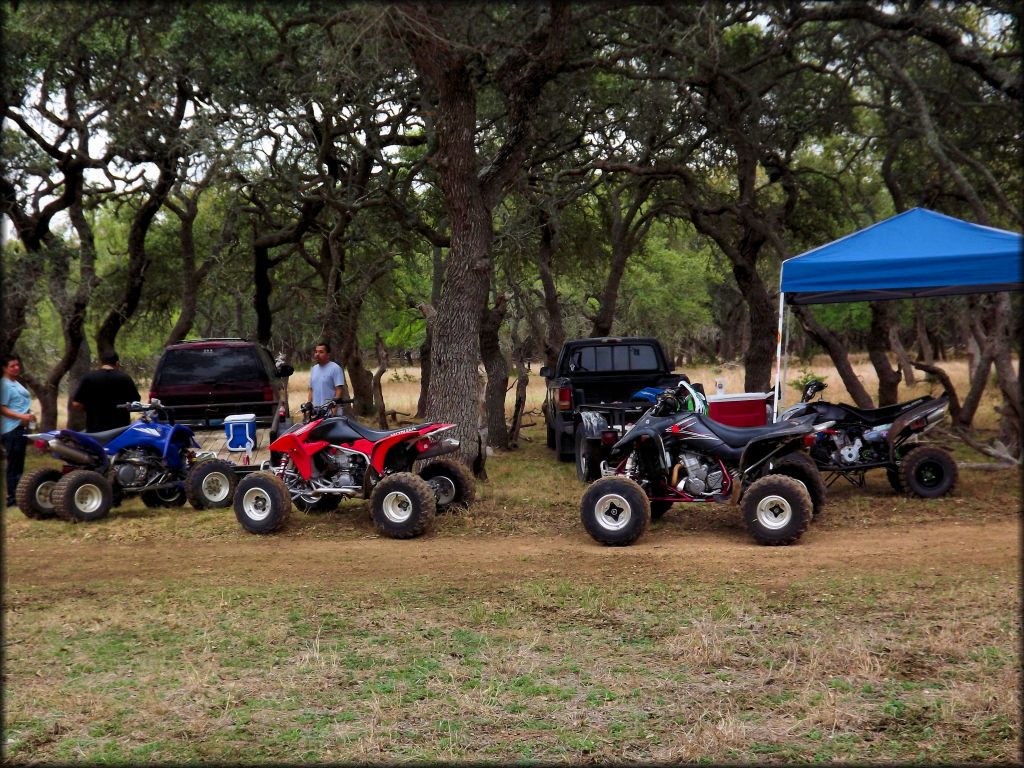 Some visitors relax and enjoy some drinks under the trees after an ATV ride.