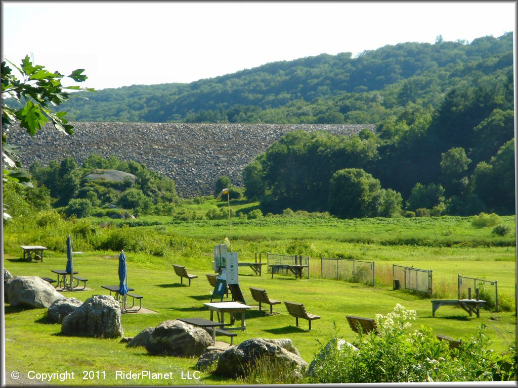 Photo of model aircraft flying field with picnic tables, umbrellas and benches.