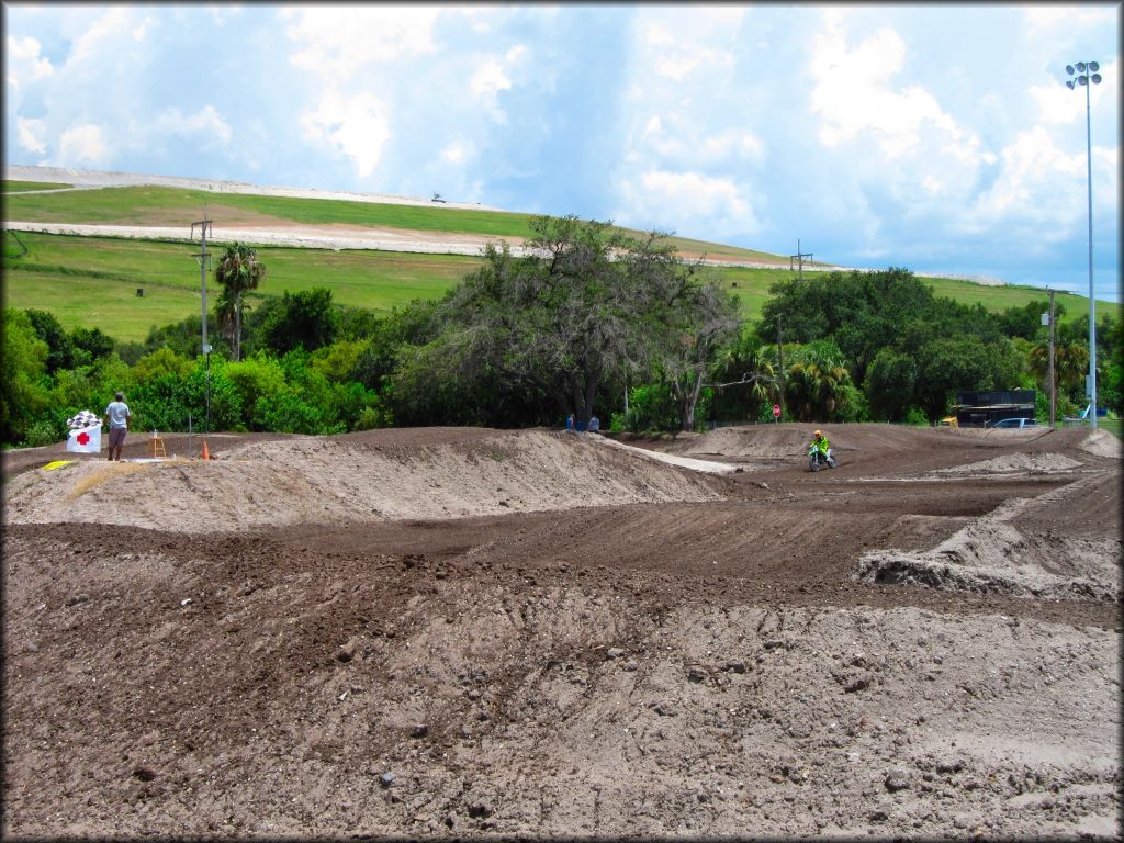 Kawasaki dirt bike heading toward table top on motocross track.