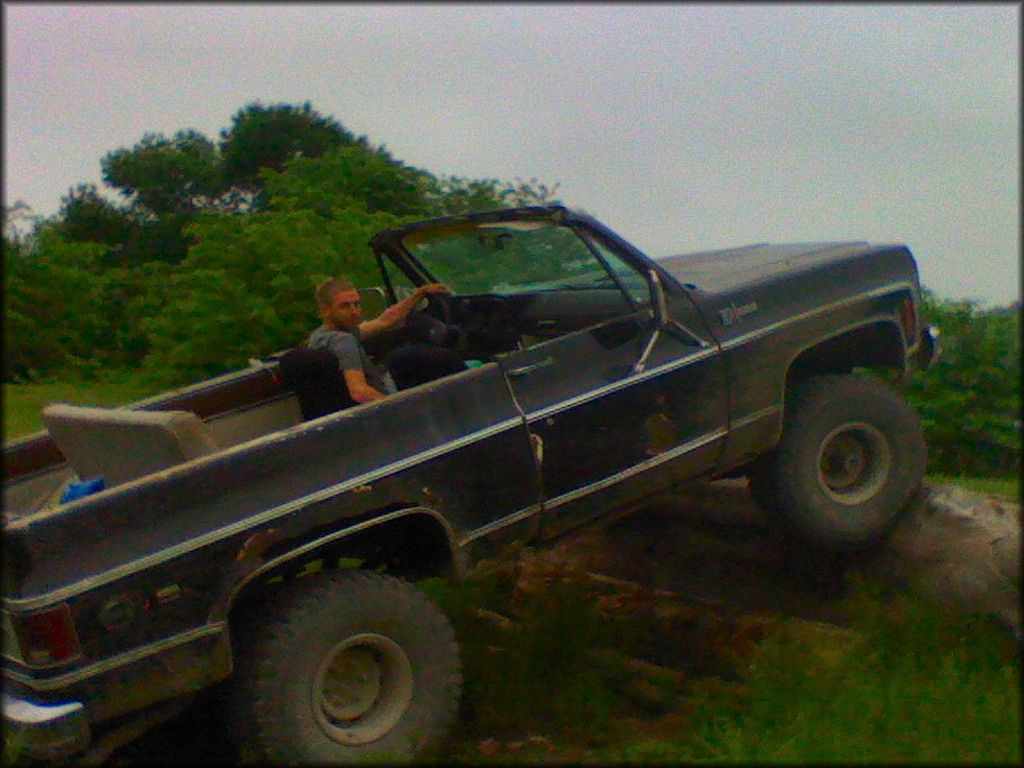 Ford truck 4x4 crawling over large log.