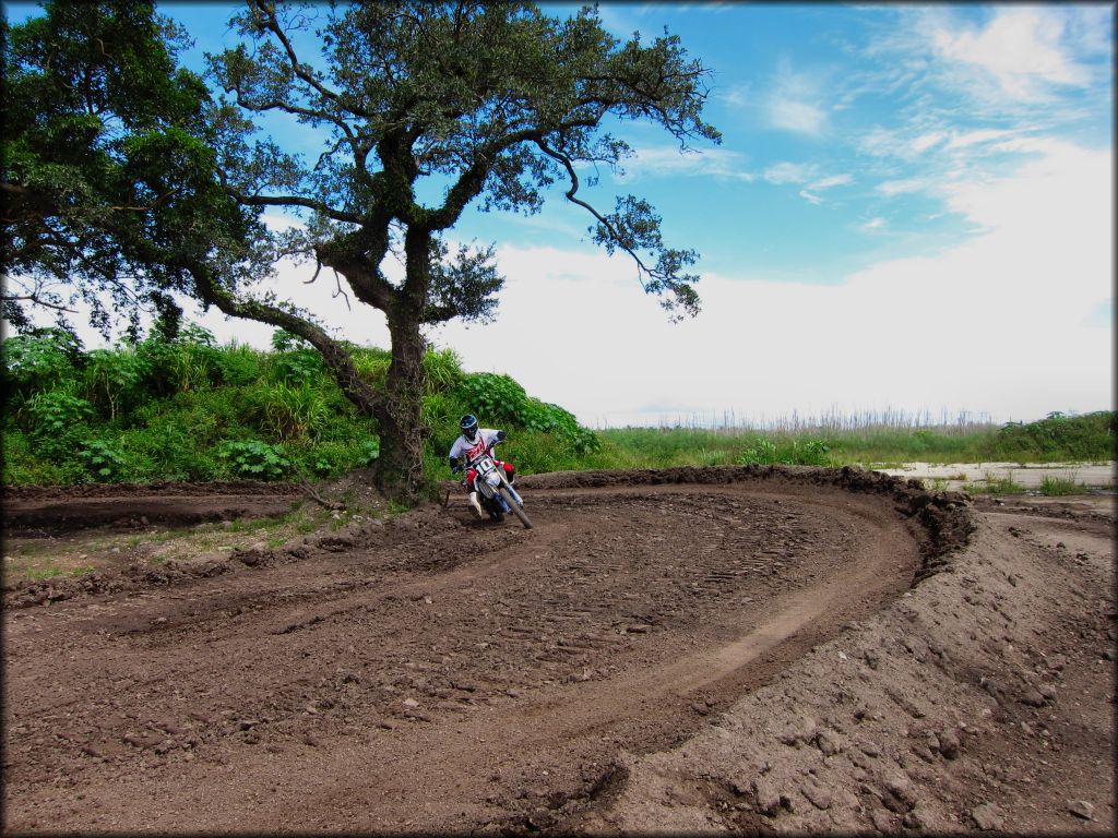 Blue Yamaha dirt bike taking a corner on motocross track.