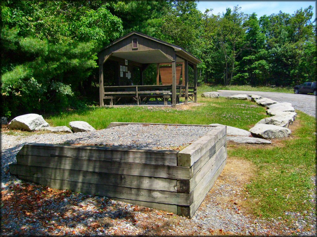 A close up photo of ATV loading ramp with gazebo in the background with picnic tables and information kiosk.