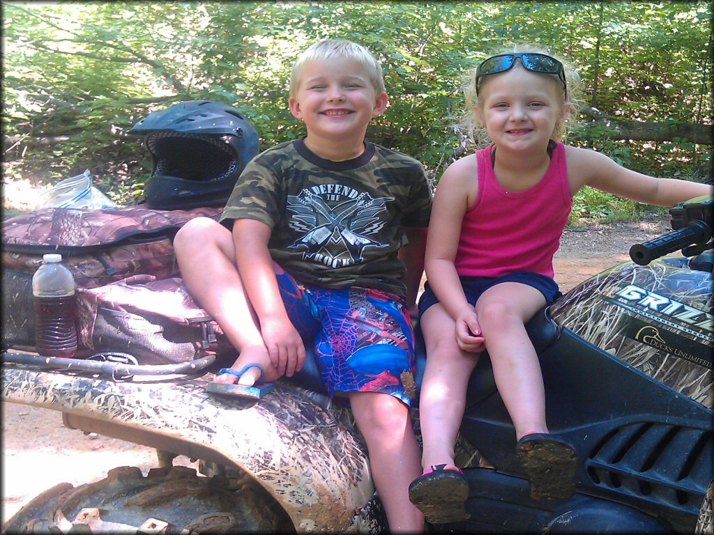 Two children sitting on a Yamaha Grizzly ATV.