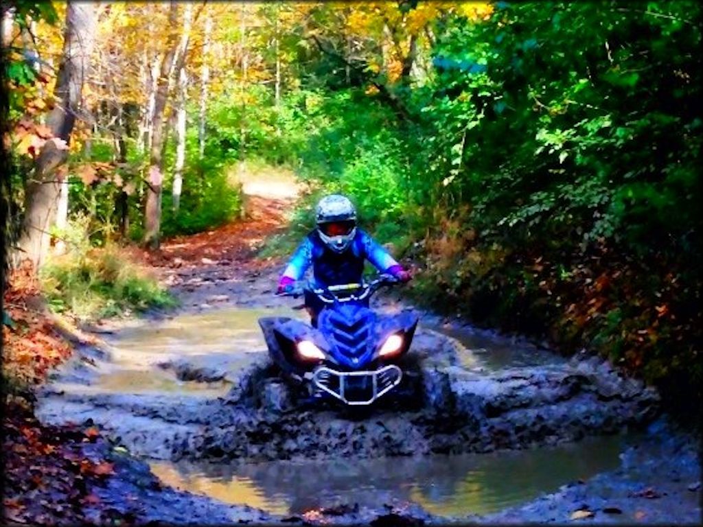 Yamaha Raptor 700R navigating through a deep mud puddle.