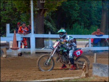 Kawasaki two-stroke dirt bike on dirt drag starting line.