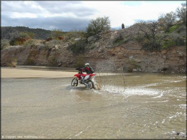 Honda CRF Dirt Bike crossing the water at Black Hills Box Canyon Trail