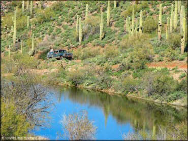 Ford Bronco with metal crate on the roof crawling up rocky 4x4 trail.