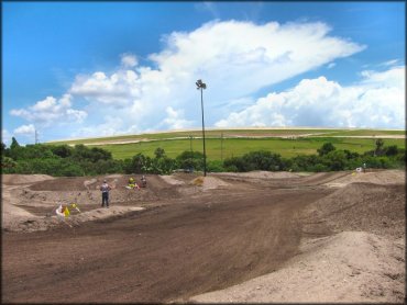 Safety flagger and two dirt bikes on motocross track.