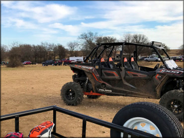 View of staging area taken from back of trailer with Polaris 1000 RZR and 4x4 trucks in the background.