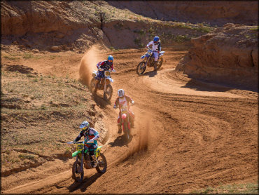 Four MX Riders Traversing Some Turns in a Sandy Wash