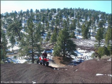 Red Honda TRX 250EX going up steep hill climb.