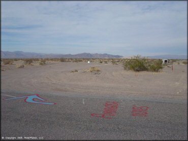 Up close photo of main entrance road with spray painted arrow on pavement.