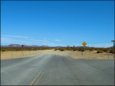 View of paved road ending and turning to dirt.