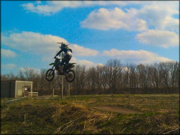 Kawasaki KX Motorbike getting air at Cambridge OHV Park Trail