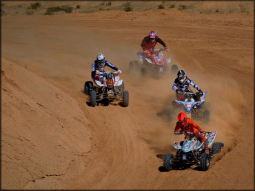 Four ATV Riders Navigating a Flat High Speed Turn