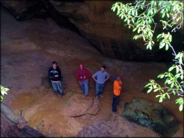 Group of young men looking up at rock walls.