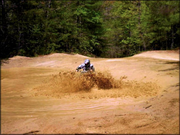 Man going through deep mud pit on dirt bike.