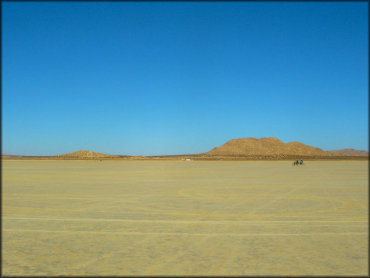 View of flat lakebed with two dirt bikes.