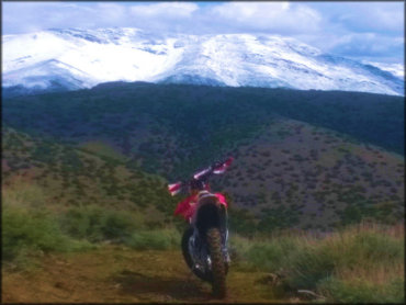 Honda Motorcycle On Trail With Mountain Backdrop