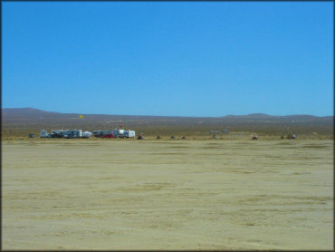 Group of RVs, trucks and ATVs near the lake bed.