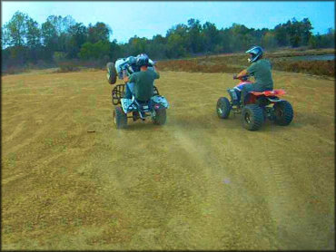 Young man popping a wheelie on ATV.