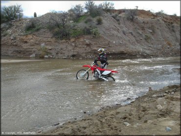 Honda CRF Motorcycle crossing the water at Black Hills Box Canyon Trail