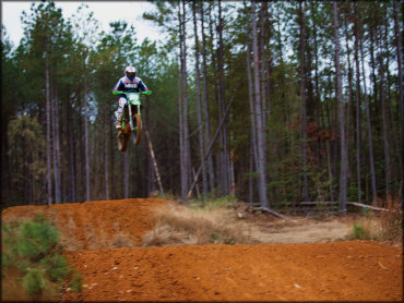 A motocross rider jumping on a Kawasaki dirt bike