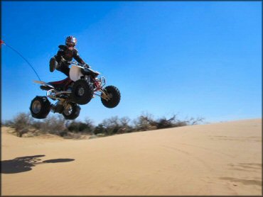 Rider catching some air on ATV with paddle tires.