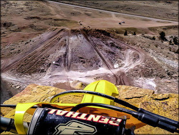 A Rider's View Atop a Suzuki RM450 Looking Down Over A Large Basin of Trails