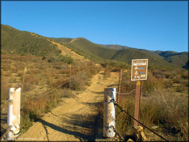 Forest Service brown carsonite trail marker designating difficulty level and permitted use.