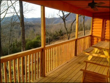 View from log cabin porch with ceiling fan and picnic table.