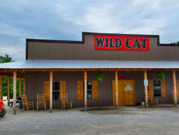 Office and general store with picnic tables, rocking chairs and gravel parking.