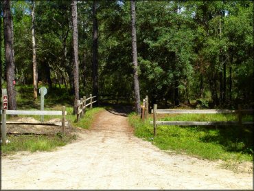 ATV trail with Forest Service signage and wooden fencing.