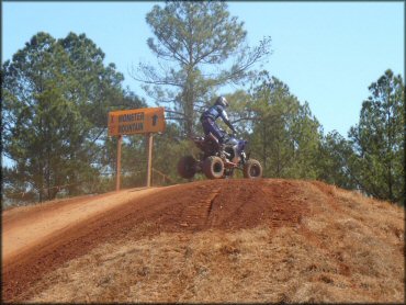 Young man on Yamaha four wheeler riding on motocross track.