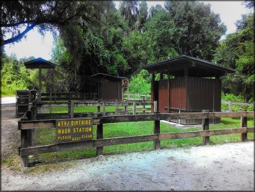 ATV spray wash station with resrooms and trash cans.