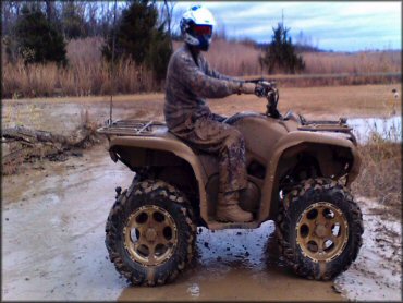 ATV and rider covered in mud.