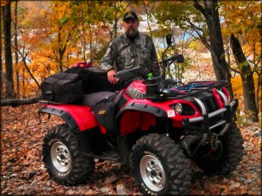 Man wearing camouflage riding gear standing next to Yamaha Grizzly with Maxxis Bighorn tires.